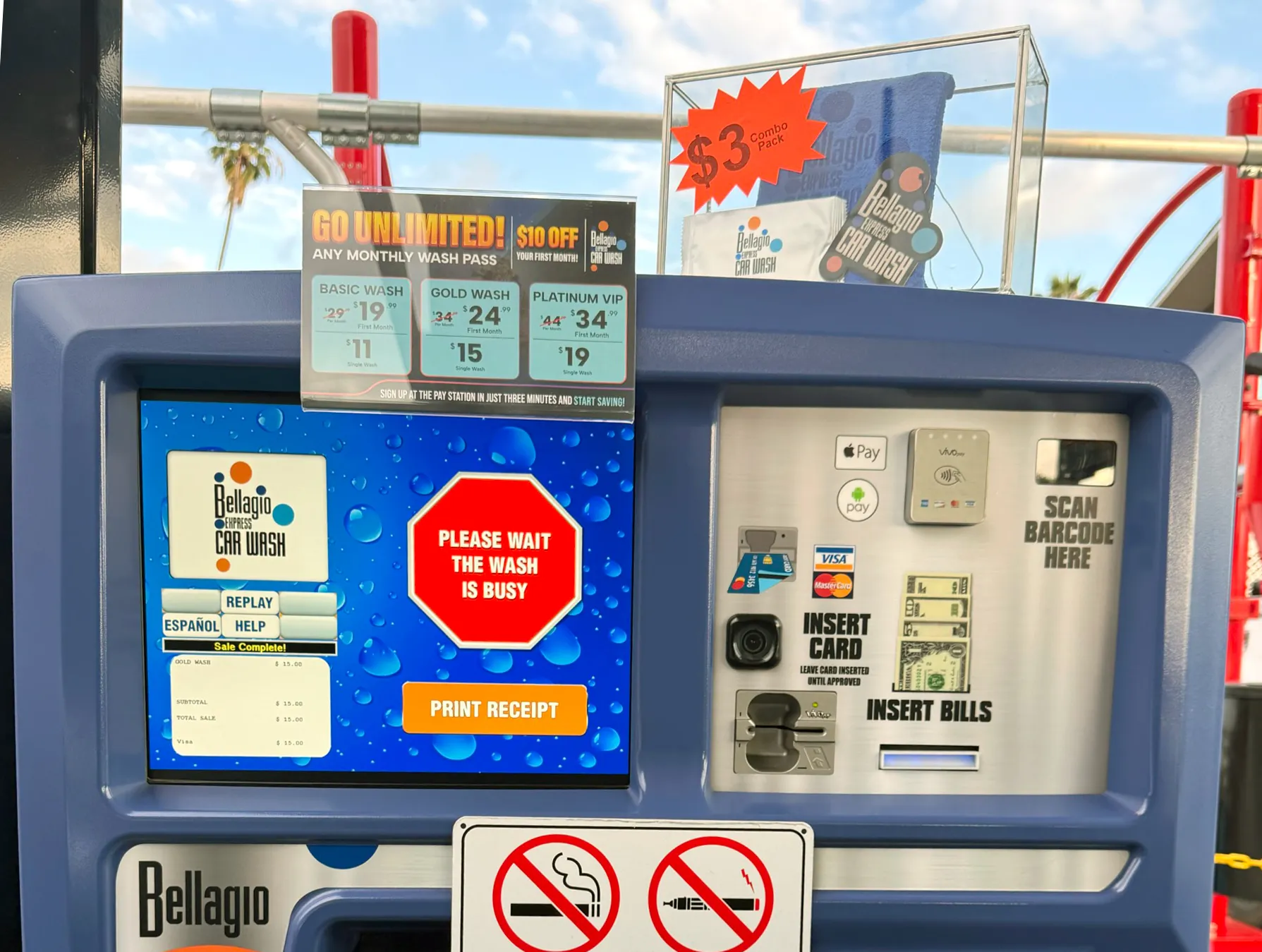Outdoor car wash payment kiosk with touchscreen and contactless reader.